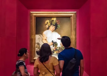 Besucher stehen vor Caravaggios Gemälde Bacchus in den Uffizien in Florenz