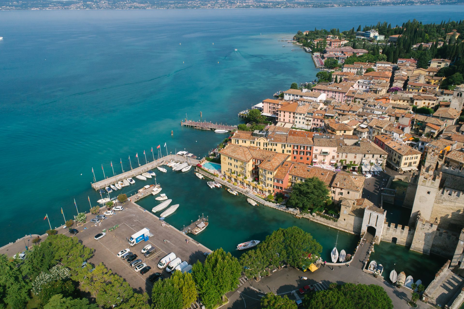 Luftaufnahme der Halbinsel Sirmione im Gardasee mit Altstadt, Scaligerburg und klarem Wasser