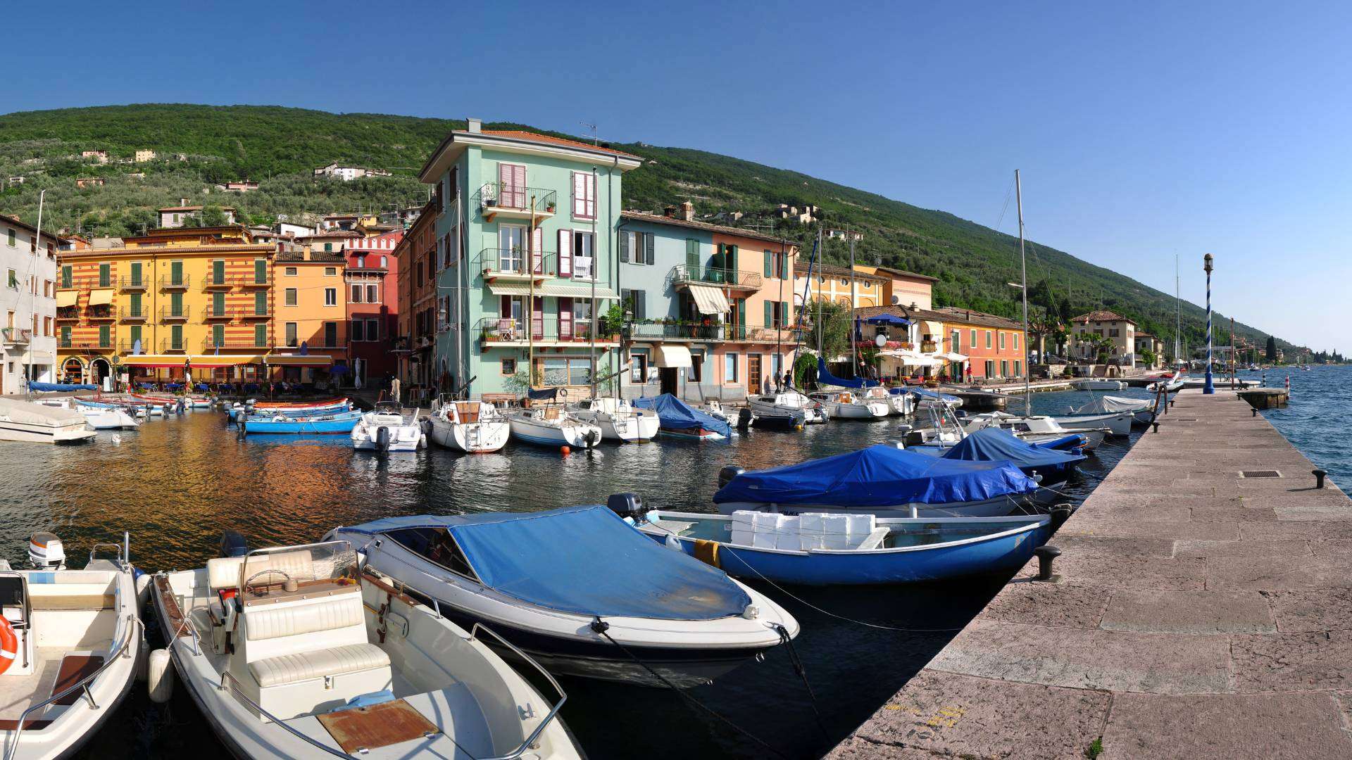 Kleiner Hafen von Castelletto di Brenzone mit Booten und bunten Häuserfassaden