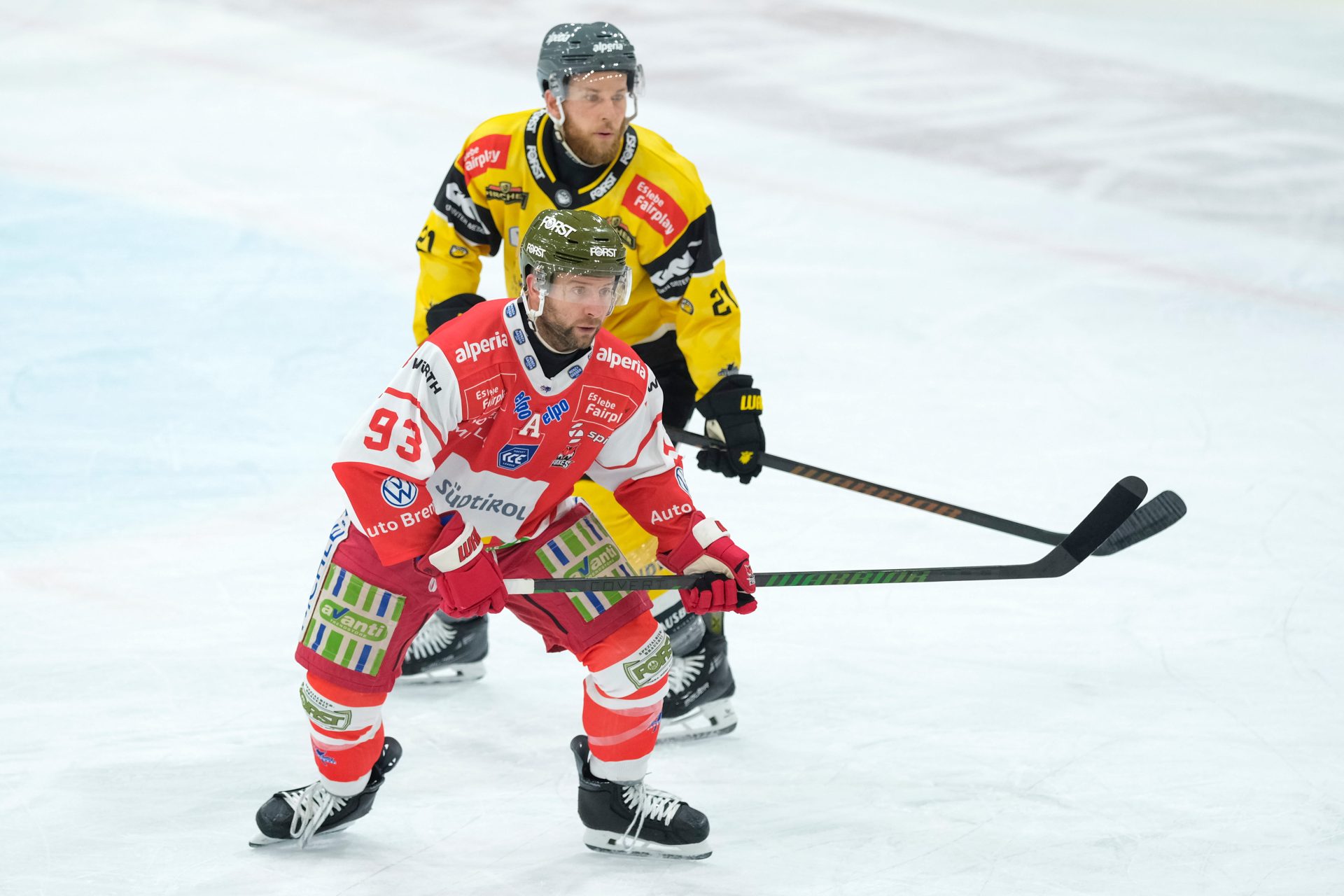 Spieler des HCB Südtirol in Rot-Weiß und des HC Pustertal in Gelb-Schwarz beim Eishockey-Derby
