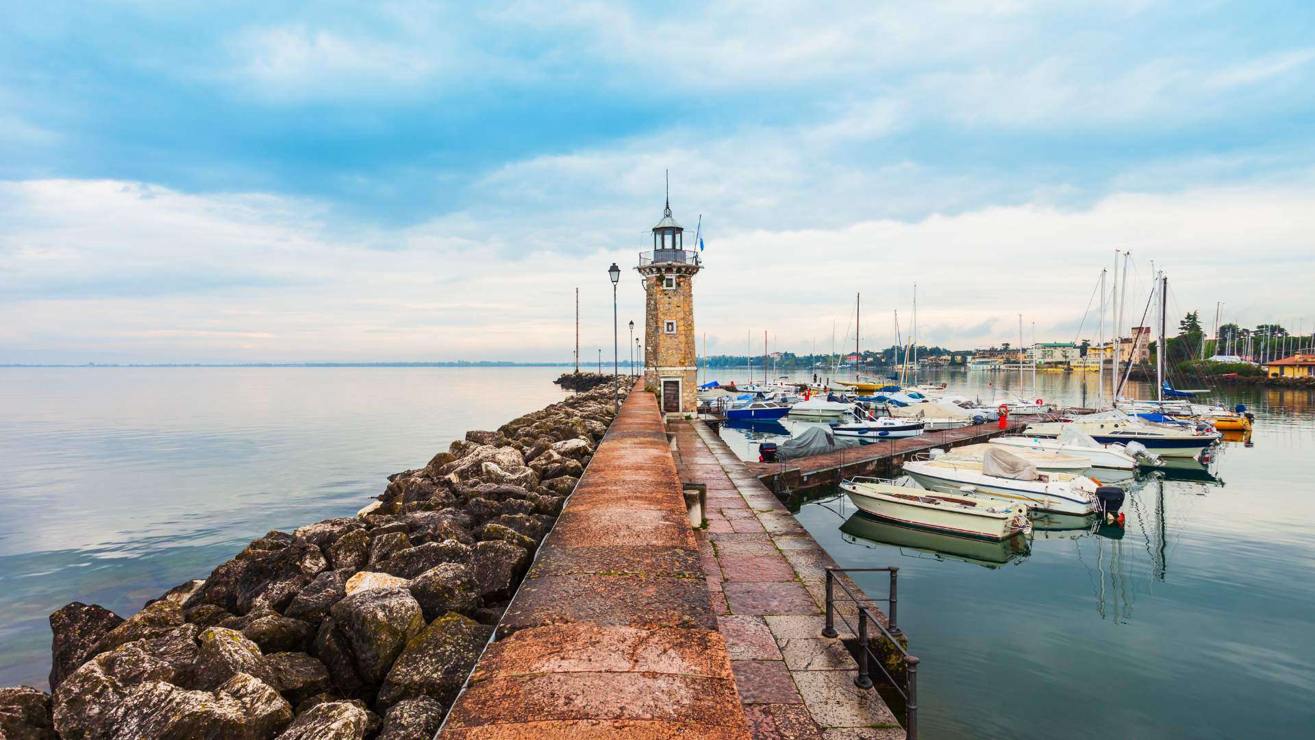 Mole mit kleinem Leuchtturm und Booten im Hafen von Desenzano del Garda