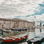 Boote vor der Mauer der Dogana Veneta im Hafen von Lazise