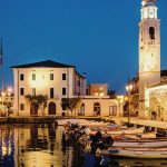 Der Hafen von Lazise am Abend mit dem beleuchteten Glockenturm von San Nicolò