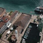 Senkrechtes Luftbild auf den Hafen von Lazise mit Booten und Dächern