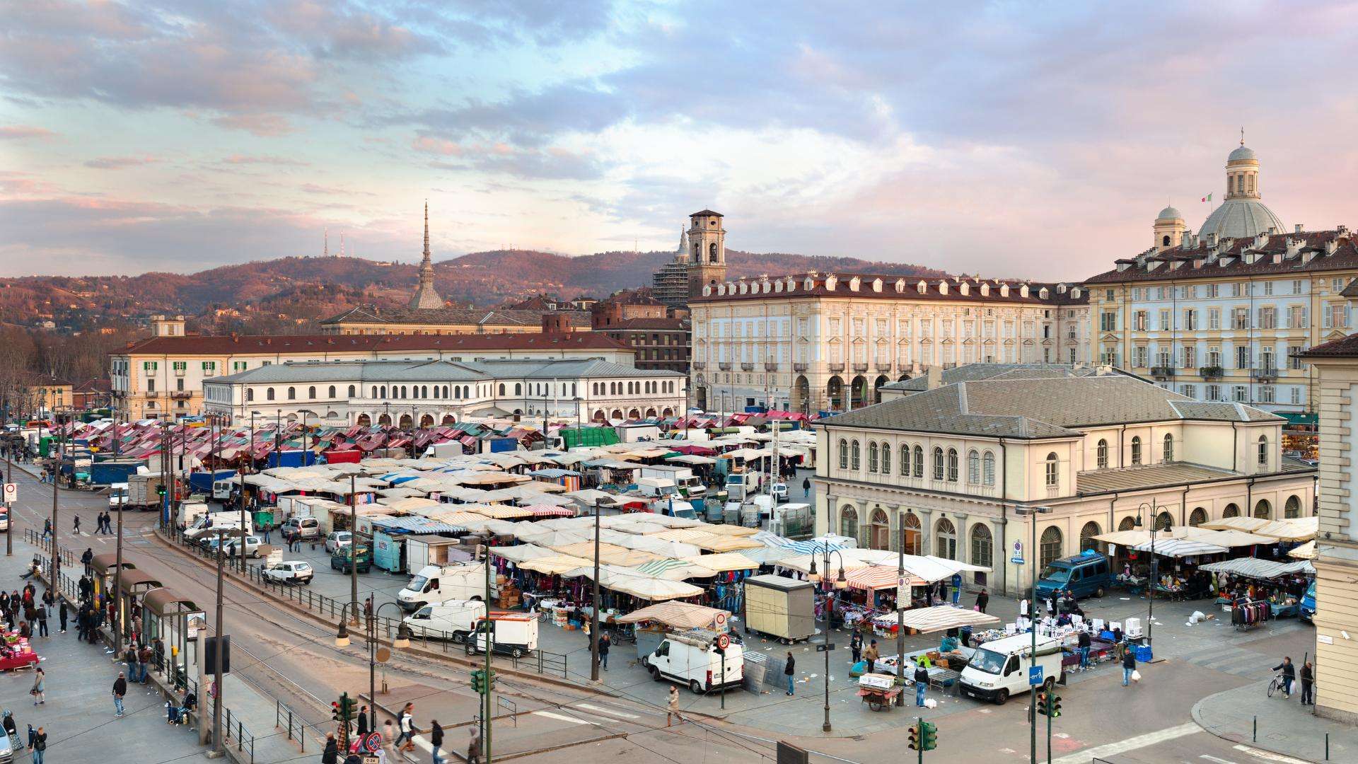 Der Markt an der Porta Palazzo Marktstände auf der Piazza della Repubblica in Turin, dahinter die Hügel über der Stadt
