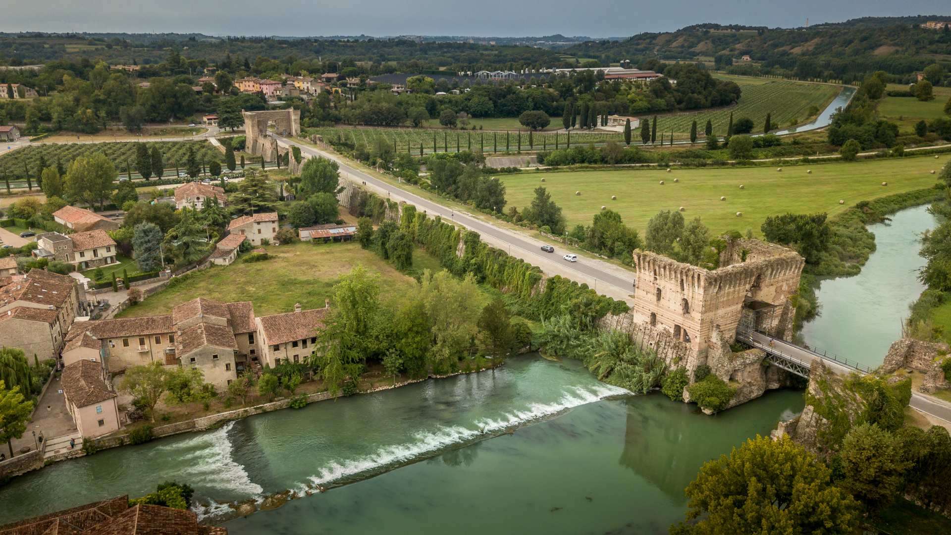 Valeggio sul Mincio – Ponte Visconteo von oben Der Ponte Visconteo quert den Mincio bei Borghetto, Luftaufnahme mit Wehr und Mühlendorf