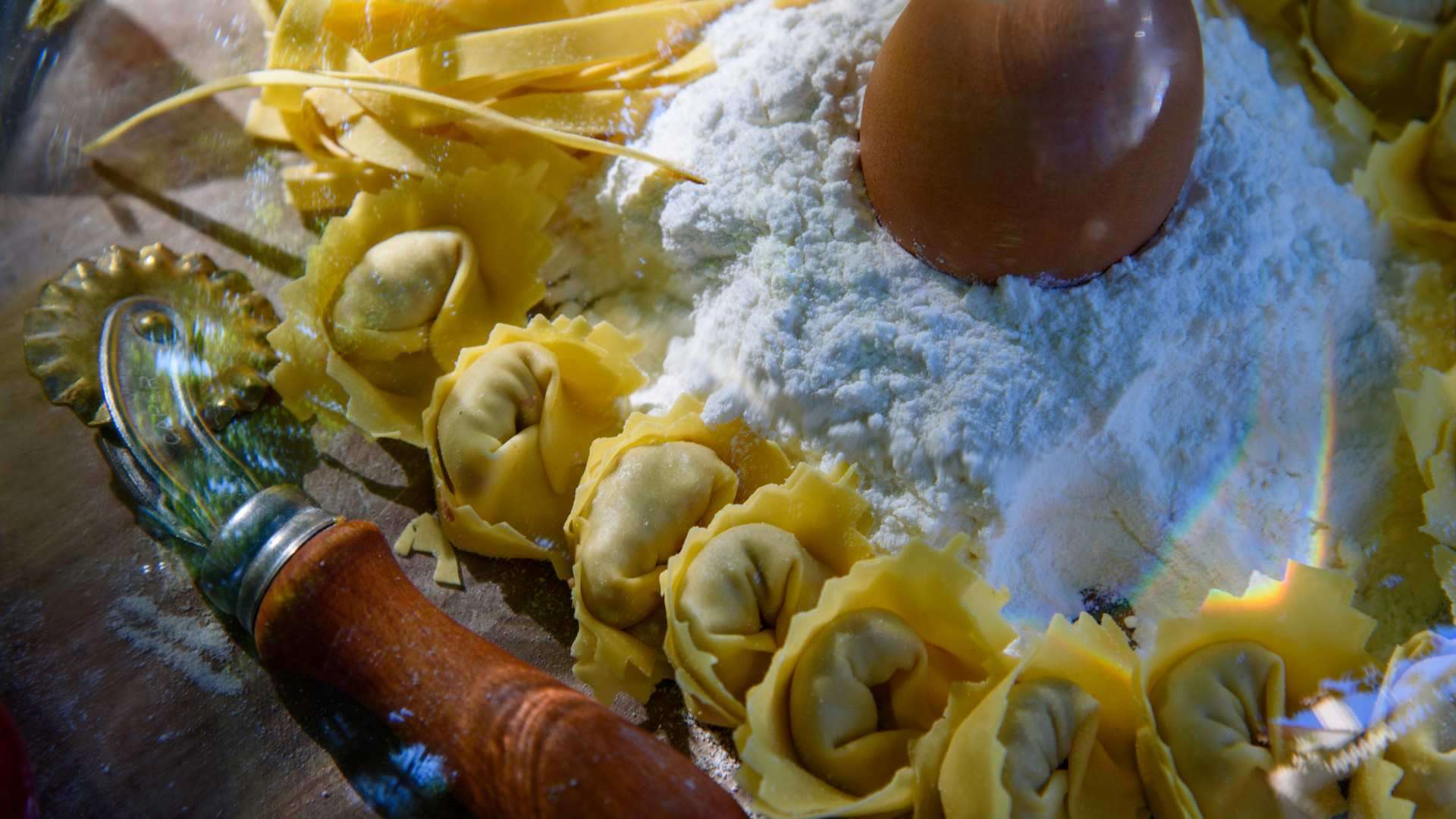 Valeggio sul Mincio – Tortellini Nodo d'Amore Frisch geformte Tortellini aus hauchdünnem Teig auf bemehltem Brett neben einem Nudelholz