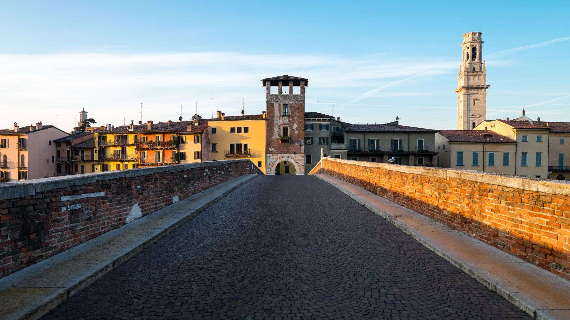Ponte Pietra in Verona mit Torbau Gepflasterter Brückenweg der Ponte Pietra in Verona mit dem zinnenbewehrten Torturm am Ende