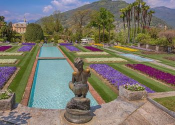 Wasserlauf zwischen violetten und weißen Blumenbeeten in den Terrassengärten der Villa Taranto in Verbania