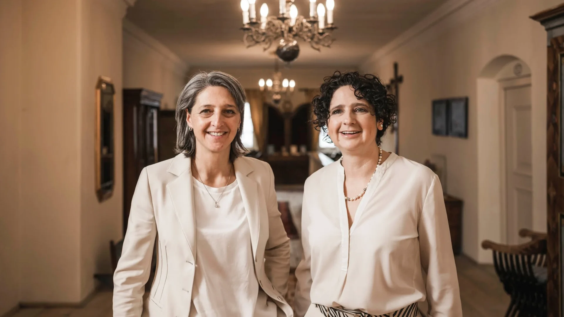 Angelika und Irene Stafler im historischen Flur des Romantik Hotel Stafler unter dem Kronleuchter