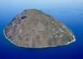 Die Insel Alicudi mit steilen Hängen und Küstensiedlung im blauen Tyrrhenischen Meer, von Süden aus der Luft gesehen