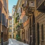 Enge Kopfsteinpflastergasse im Viertel Brera in Mailand mit Balkonen, Fensterläden und Kletterpflanzen an den Fassaden