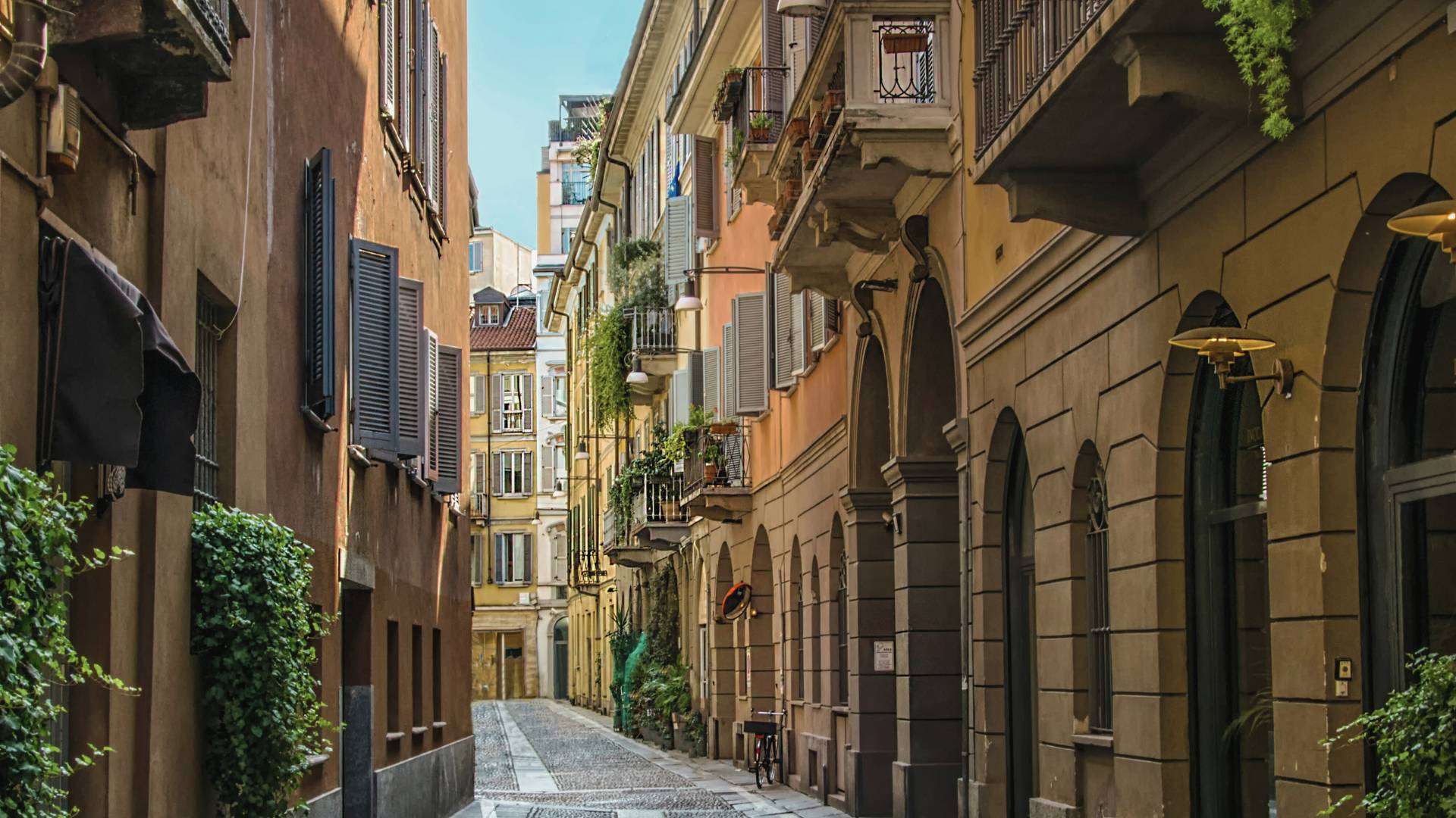 Schmale Gasse im Mailänder Viertel Brera mit alten Fassaden, Balkonen und Pflanzen vor den Häusern