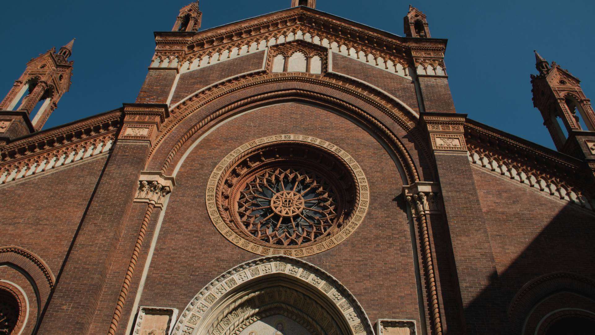 Neugotische Backsteinfassade einer Kirche mit Rosette und Spitzbogenportal im Viertel Brera in Mailand