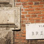 Marmornes Straßenschild mit der Aufschrift Via Brera an einer Backsteinwand in Mailand