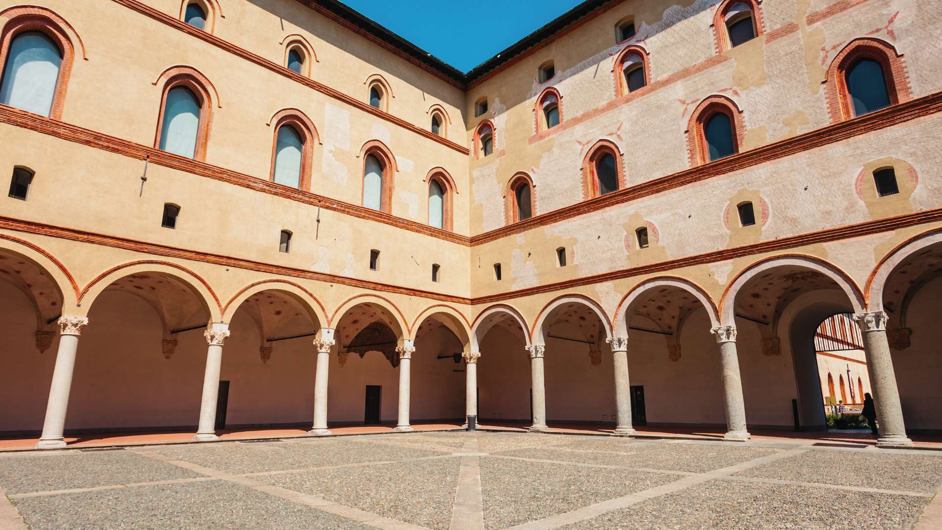 Arkadenhof im Inneren des Castello Sforzesco mit Säulengang im Erdgeschoss und Backsteinfassaden darüber