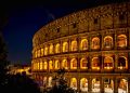 Die Fassade des Kolosseums in Rom ist bei Nacht von warmem Licht angestrahlt