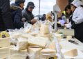 Besucher kaufen an einem Marktstand in Sogliano al Rubicone abgepackte Stücke von Formaggio di Fossa