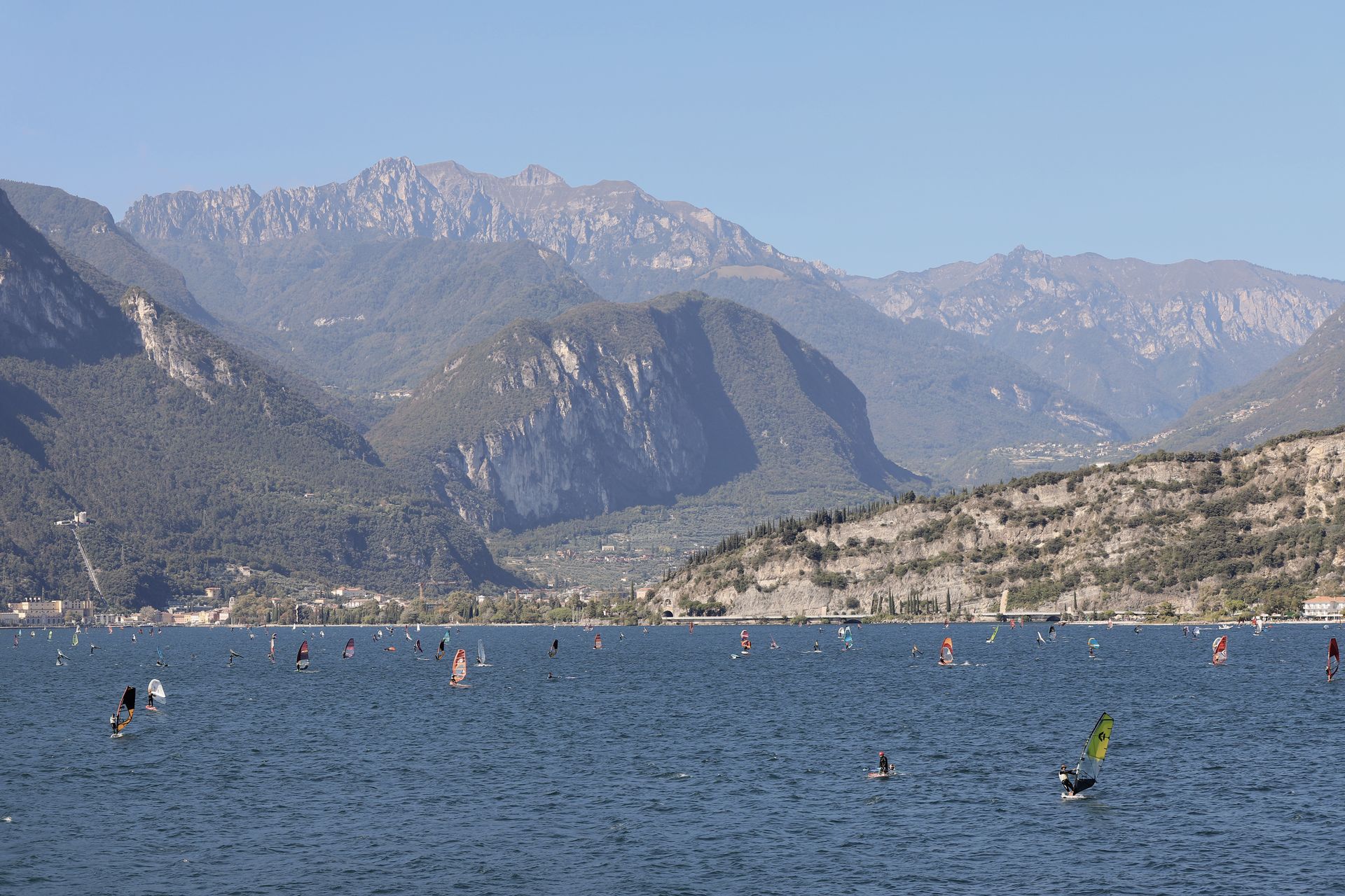 Windsurfer auf dem nördlichen Gardasee vor den Bergen am Ende des Sees