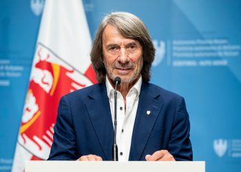 Gesundheitslandesrat Hubert Messner spricht in einem Büro, umgeben von Dokumenten und einem Bildschirm, über neue Regeln für Gesundheitstermine