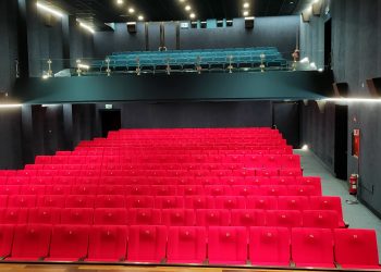 Rote Sitzreihen im leeren Cinema Italia mit einer Galerie im Hintergrund und dunklen Saalwänden