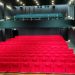 Rote Sitzreihen im leeren Cinema Italia mit einer Galerie im Hintergrund und dunklen Saalwänden