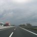 Zwei Lastwagen auf der Gegenfahrbahn der A1 bei Arezzo unter dunklem Himmel, Archivaufnahme von 2006