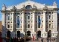 Die Fassade des Palazzo Mezzanotte an der Piazza Affari in Mailand mit hohen Säulen und Passanten