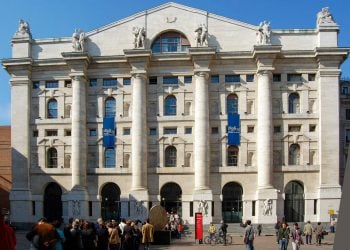 Die Fassade des Palazzo Mezzanotte an der Piazza Affari in Mailand mit hohen Säulen und Passanten