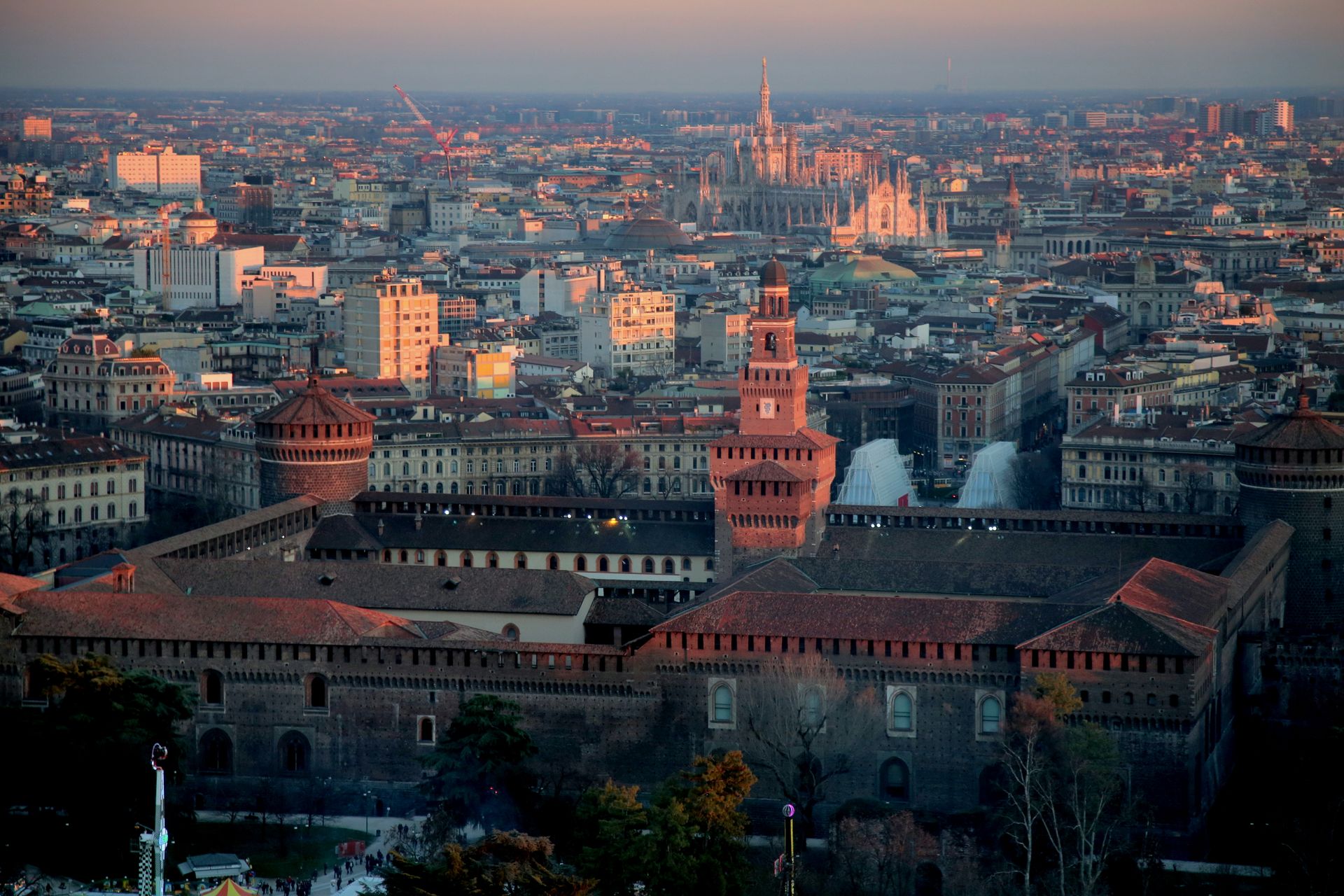 Blick über die Dächer Mailands mit dem Castello Sforzesco im Vordergrund und dem Dom im Abendlicht