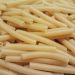 Ungekochte gelbe Makkaroni in dichter Nahaufnahme mit sichtbar hohlen Enden, Symbolbild für Pasta