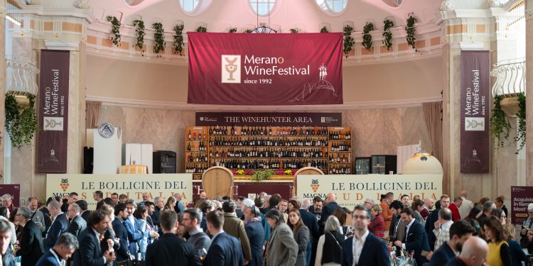 Besucher verkosten Wein im festlich geschmückten Jugendstilsaal des Kurhauses Meran beim Merano WineFestival