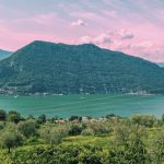 Monte Isola unter rosa Abendhimmel Monte Isola im Iseosee unter rosa Abendhimmel, im Vordergrund Bäume am Ufer