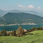 Monte Isola vom Festland aus Monte Isola im Iseosee, vom Festland über eine grüne Wiese gesehen