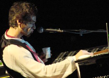 Morgan sitzt bei einem Konzert 2007 am Keyboard, vor ihm ein Mikrofon auf der dunklen Bühne
