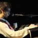 Morgan sitzt bei einem Konzert 2007 am Keyboard, vor ihm ein Mikrofon auf der dunklen Bühne