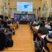 Menschen sitzen in einem Konferenzraum und verfolgen eine Präsentation über die Territorialen Bildungsräume in Bozen.
