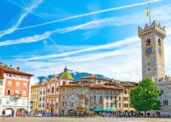 Piazza Duomo in Trient mit Neptunbrunnen, Torre Civica und bemalten Hausfassaden unter blauem Himmel