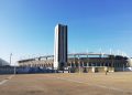 Außenansicht des Stadio Olimpico Grande Torino mit seinem hohen Turm und dem Vorplatz bei blauem Himmel
