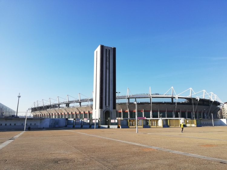 Außenansicht des Stadio Olimpico Grande Torino mit seinem hohen Turm und dem Vorplatz bei blauem Himmel